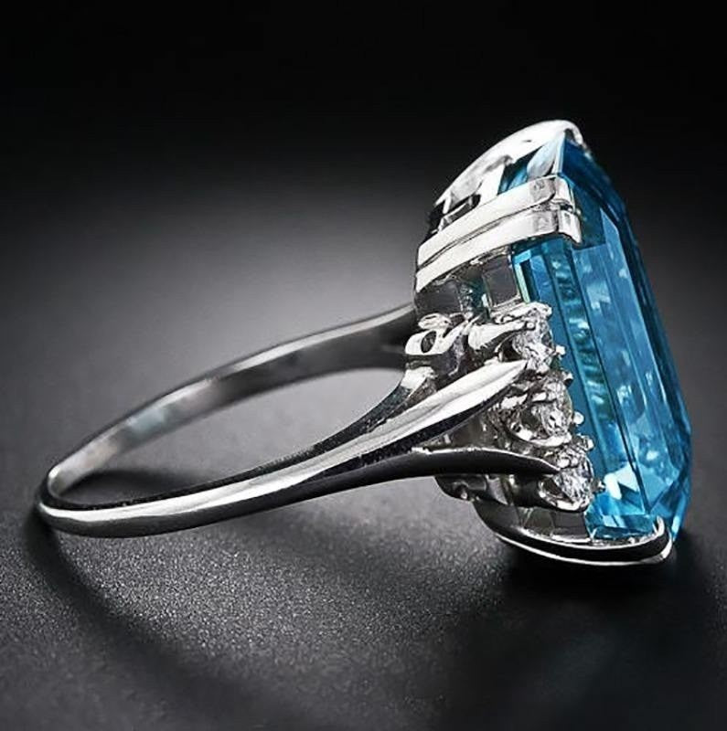 Ring with a large blue gemstone and smaller diamonds on a dark background