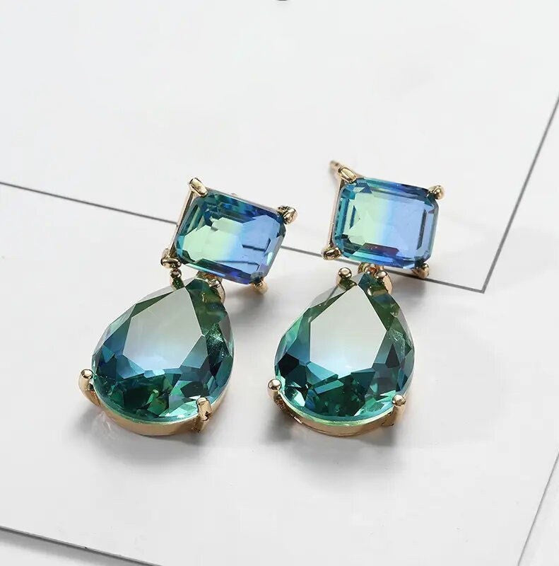 blue and gold earrings displayed on a white background