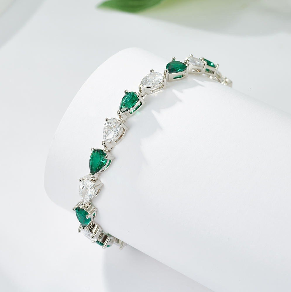Jewelry bracelet with green gemstones on a white surface