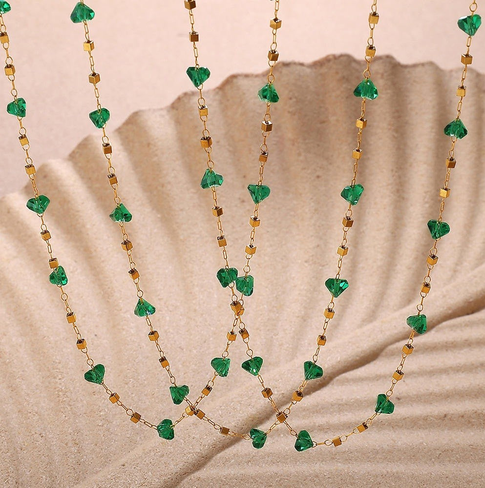 Necklace with green heart-shaped beads on a beige background