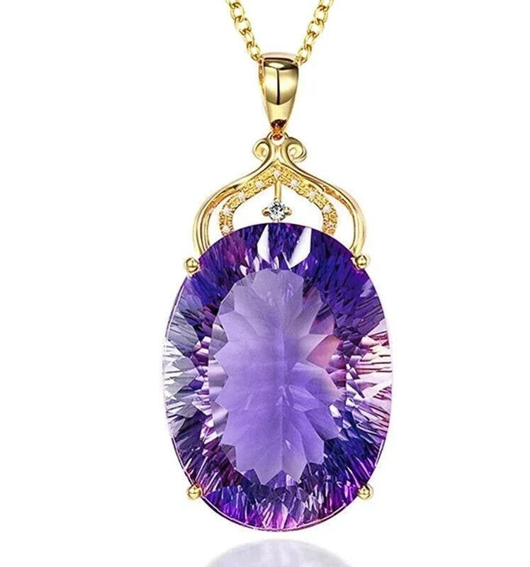 An oval purple amethyst pendant necklace in a gold setting with a small clear accent stone, shown against a plain white background.