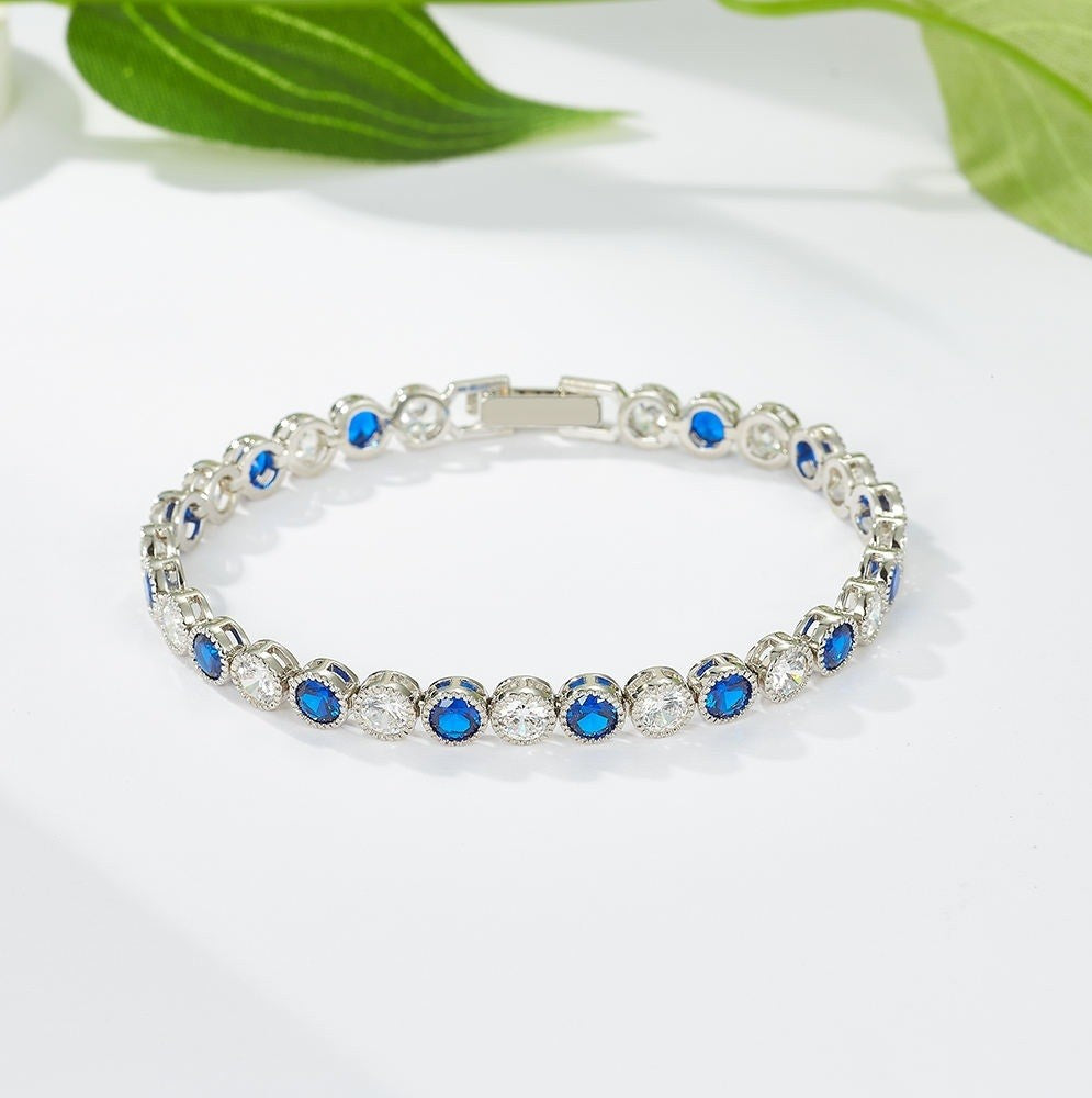 Silver bracelet with blue stones on a white background