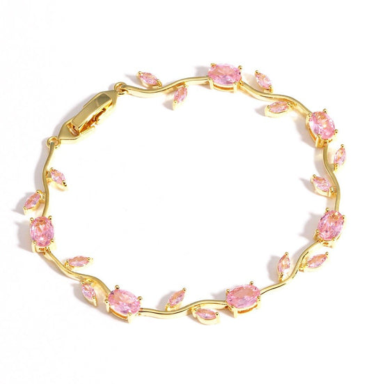 A gold leaf vine bracelet adorned with marquise-cut pink gemstones, displayed on a clean white background.