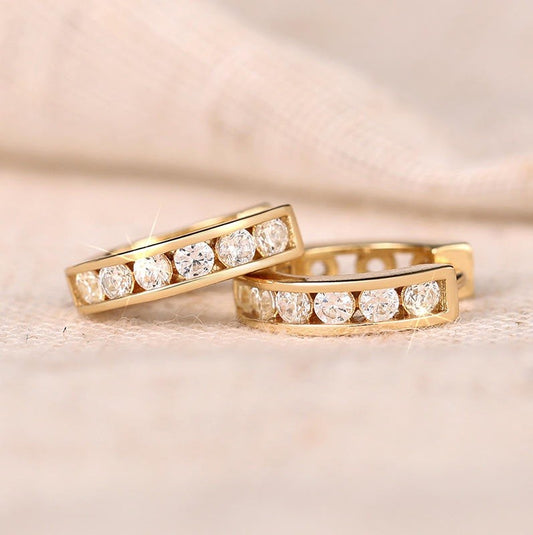 a pair of gold earrings with diamond like gemstones