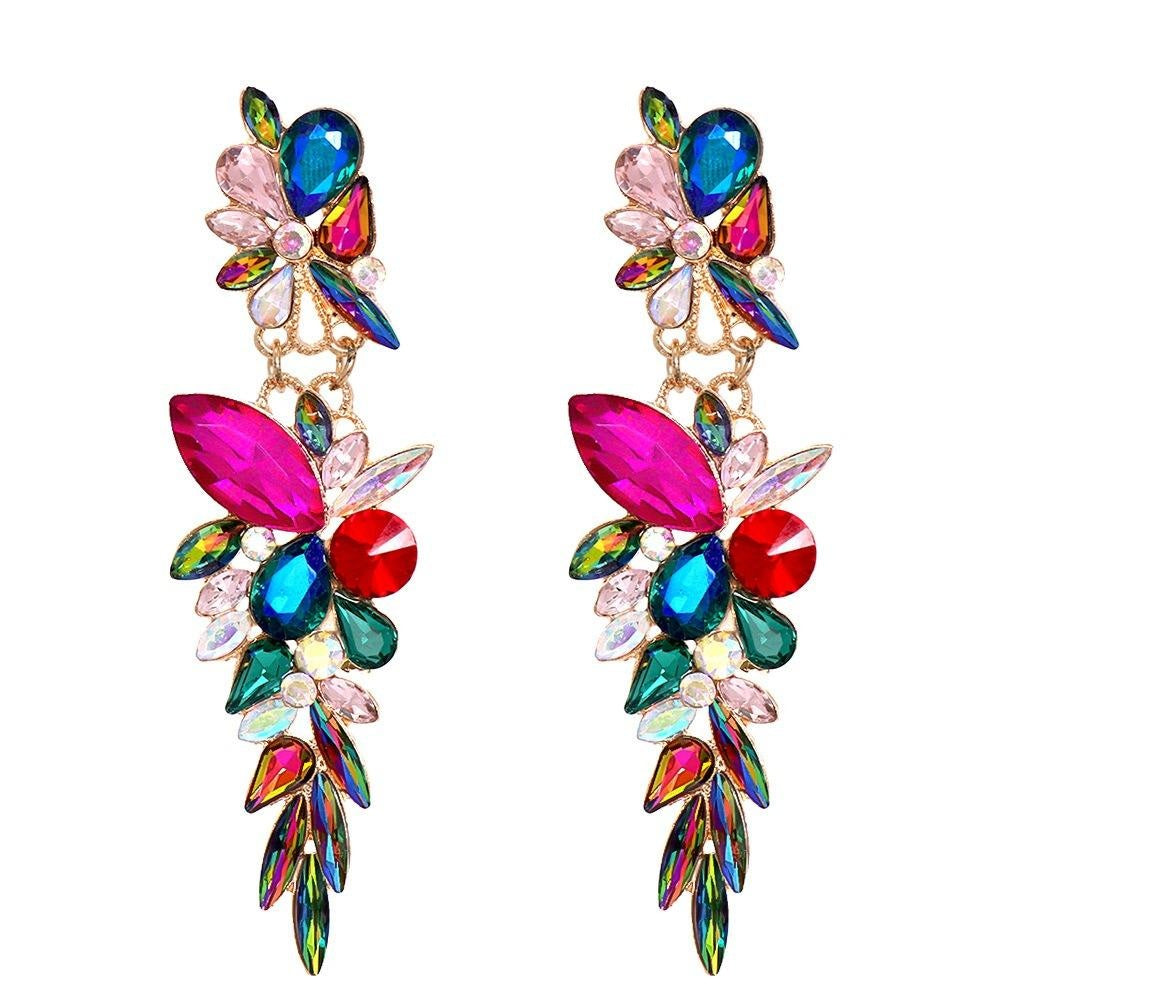 A pair of long, colorful dangling earrings with floral and leaf-shaped crystal clusters in pink, blue, green, red, and iridescent tones on a plain white background.