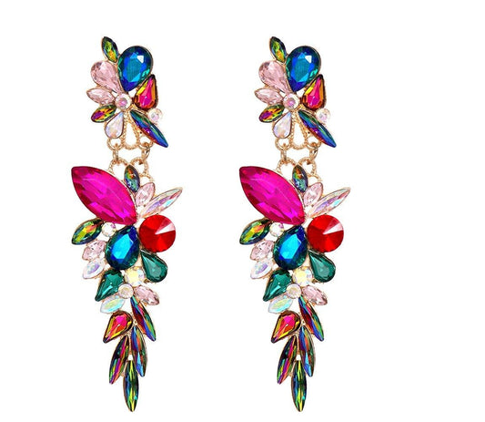 A pair of long, colorful dangling earrings with floral and leaf-shaped crystal clusters in pink, blue, green, red, and iridescent tones on a plain white background.