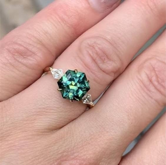 Ring with a green gemstone on a finger