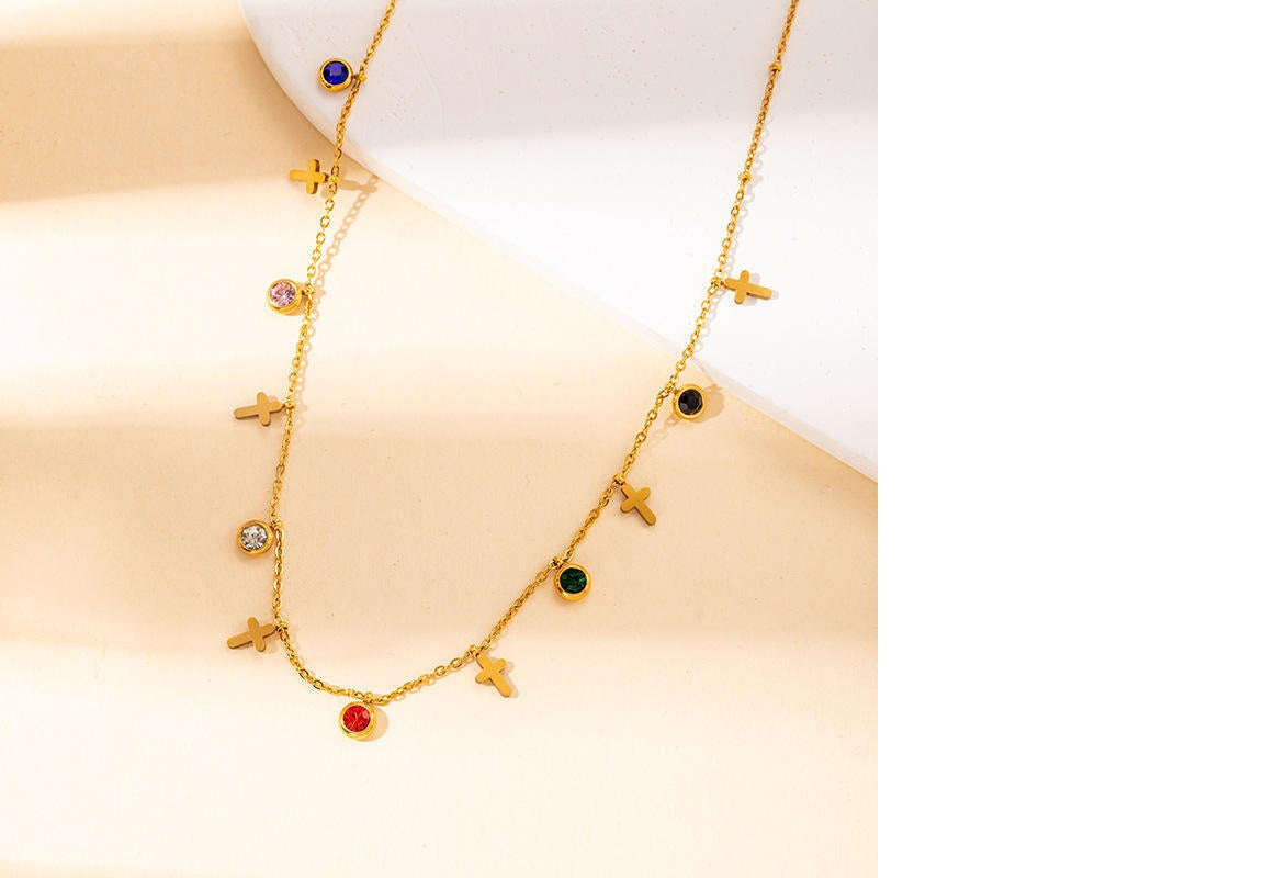 Gold necklace with colorful gemstones on a light beige background