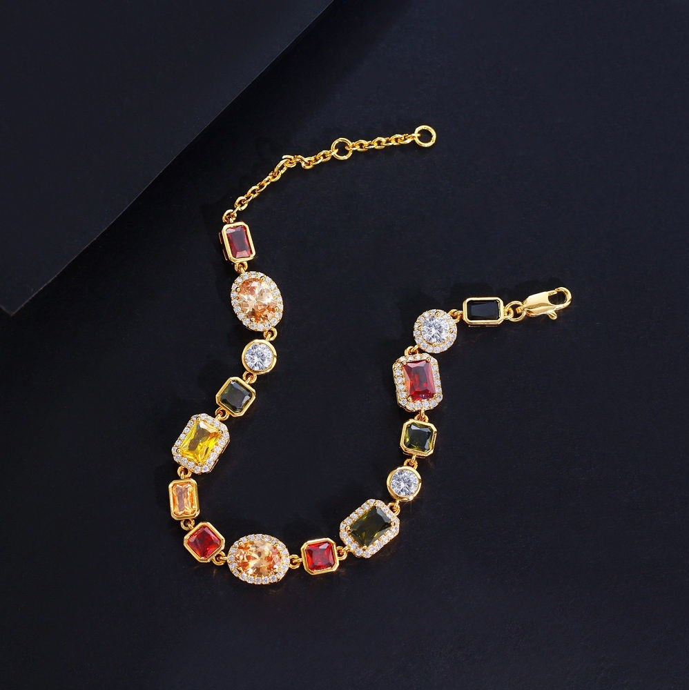 Gold bracelet with colorful gemstones on a black background