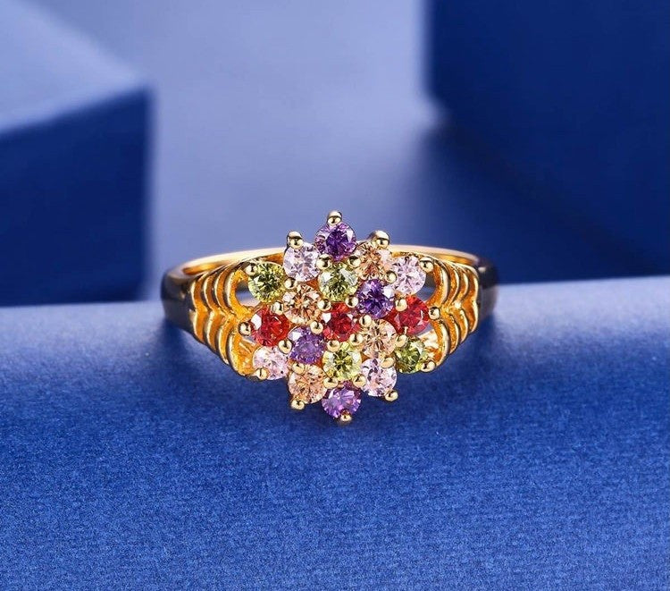 Gold ring with multicolored gemstones on a blue background