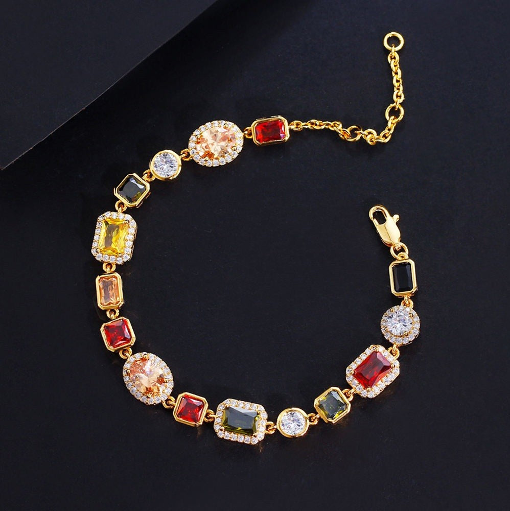 Gold bracelet with colorful gemstones on a black background