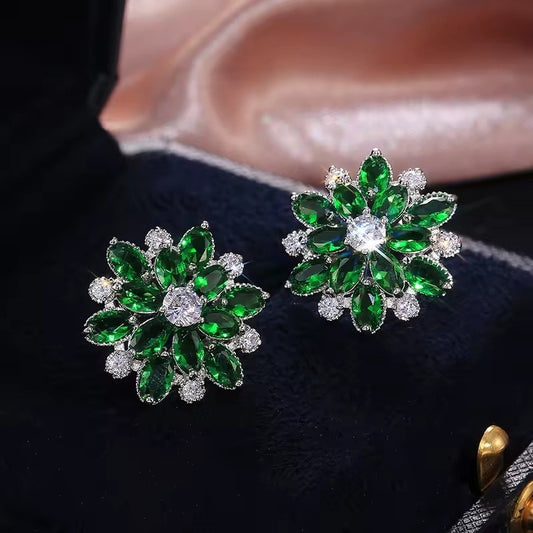 Pair of green gemstone earrings on a dark surface