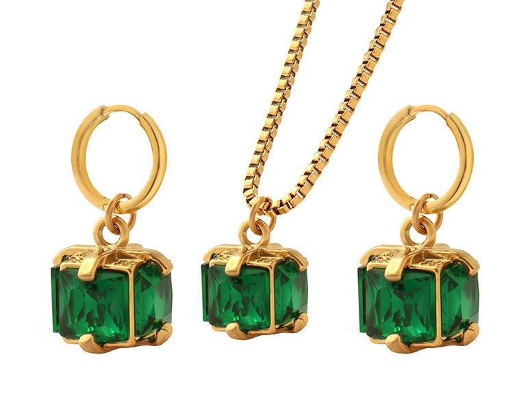 Gold necklace with green gemstone pendants on a white background