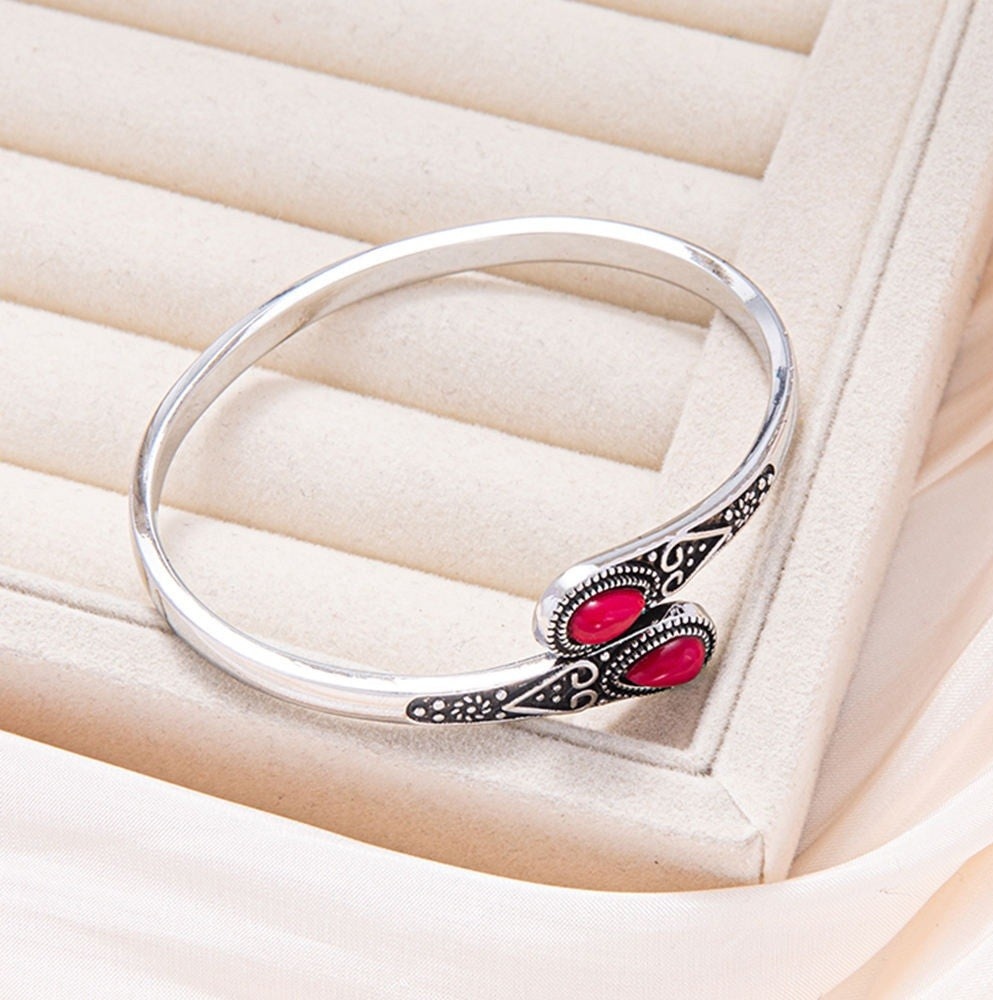 Silver and red bracelet on a cream background