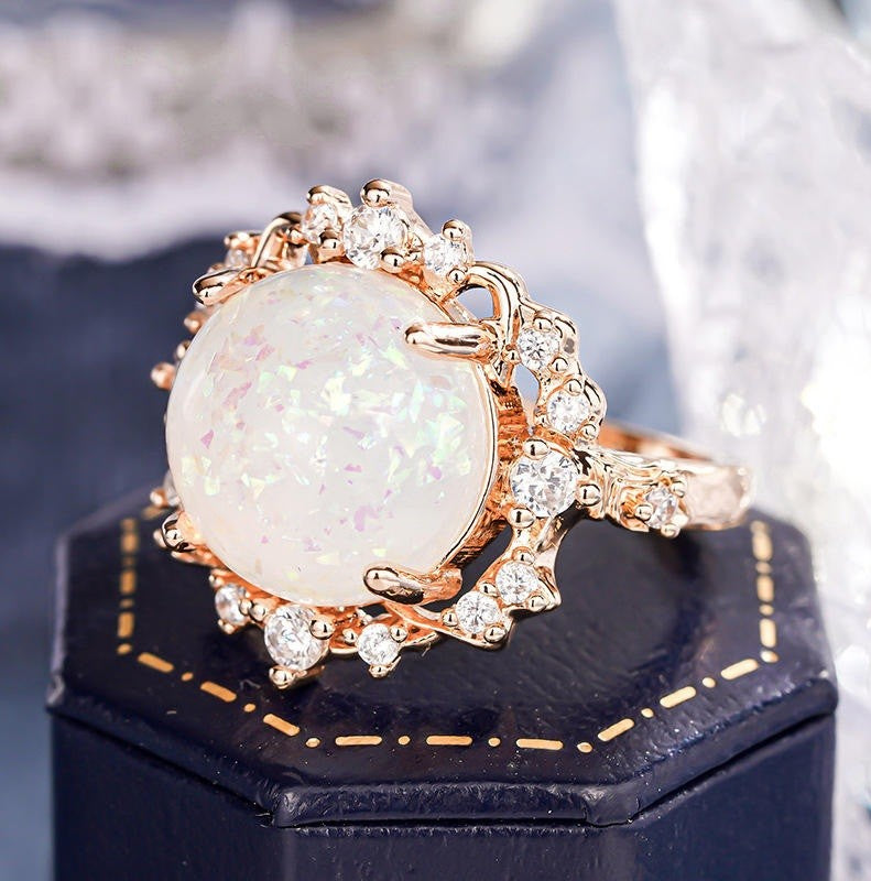 A rose gold ring featuring a large oval white opal center stone 