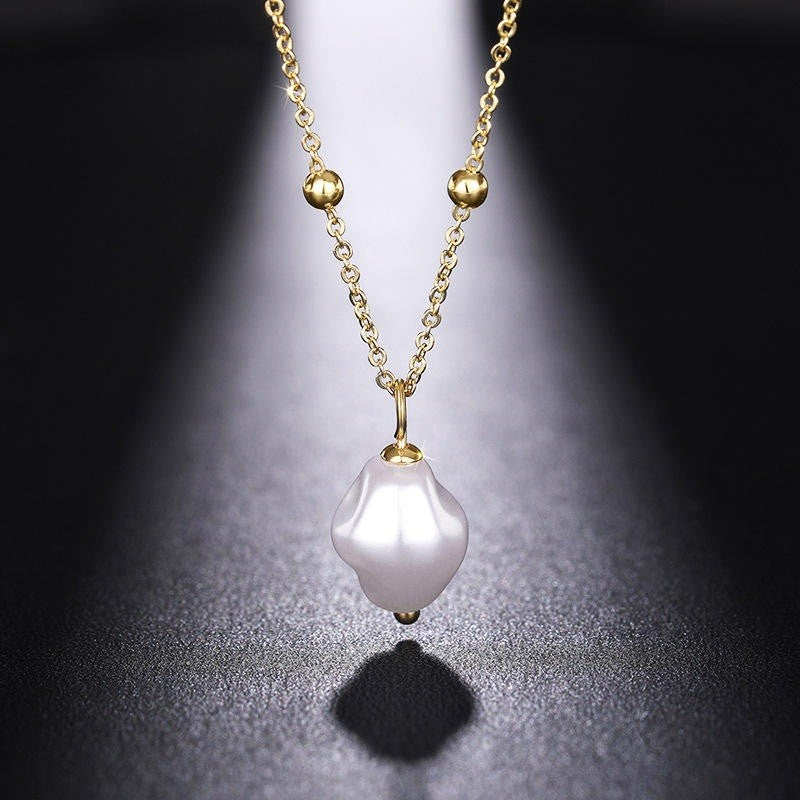 Gold necklace with a white pearl pendant on a dark background