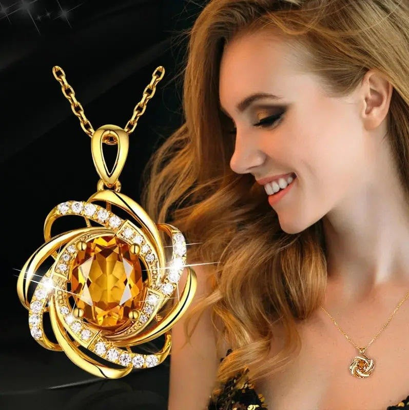 Gold necklace with a large yellow gemstone worn by a woman