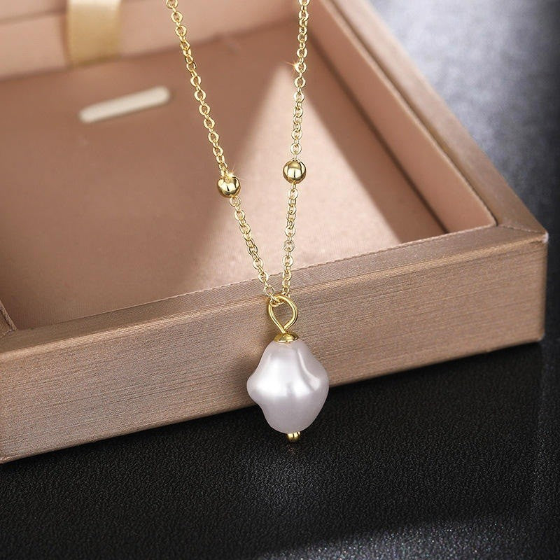 Pearl necklace with gold chain on a wooden tray