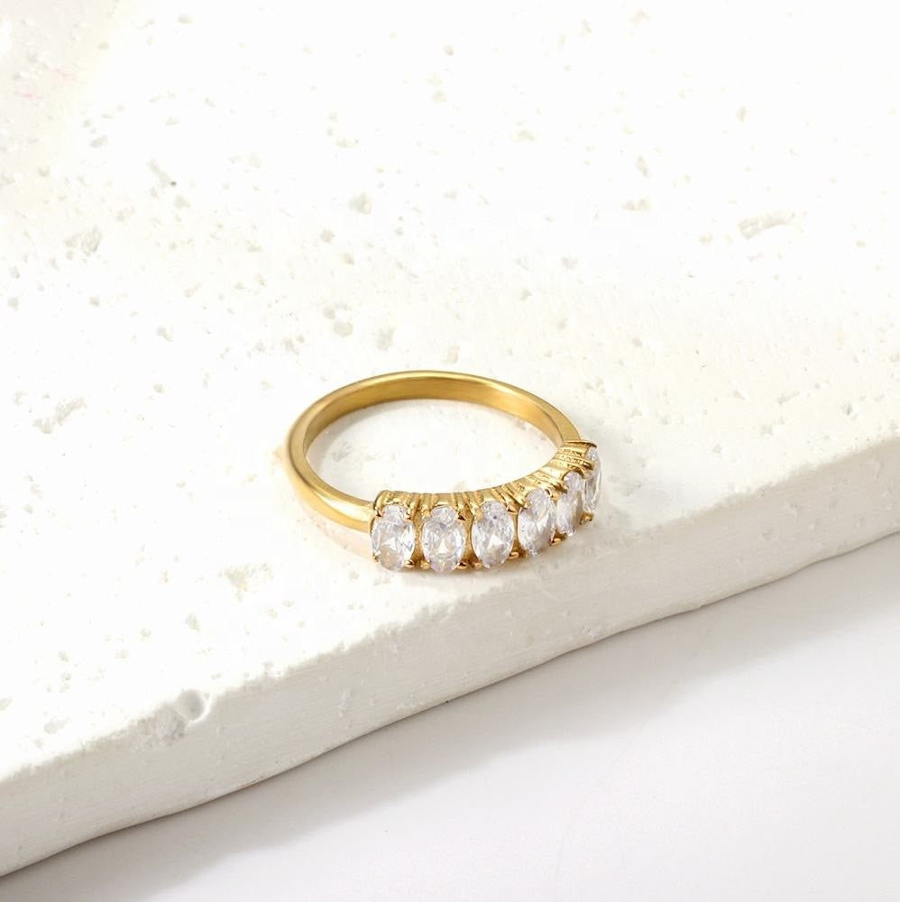 Gold ring with diamonds on a textured white surface