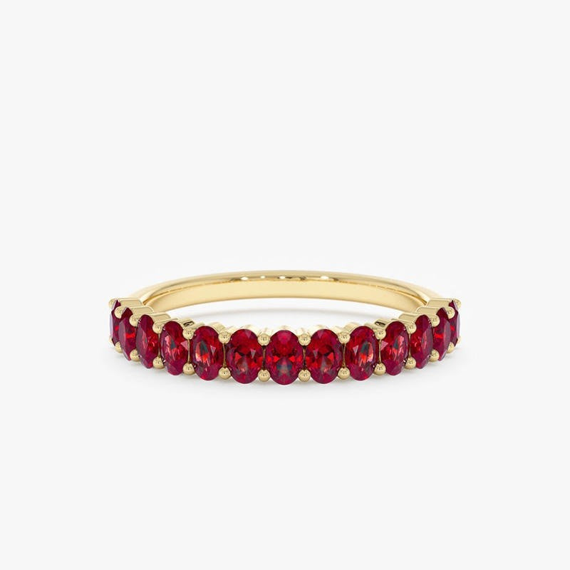 Gold ring with red gemstones on a white background