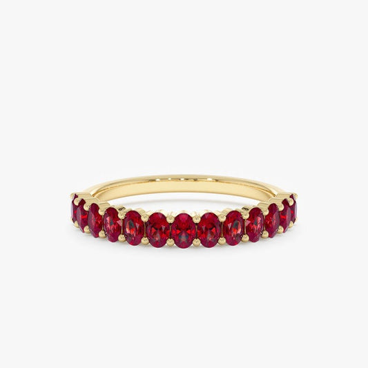 Gold ring with red gemstones on a white background