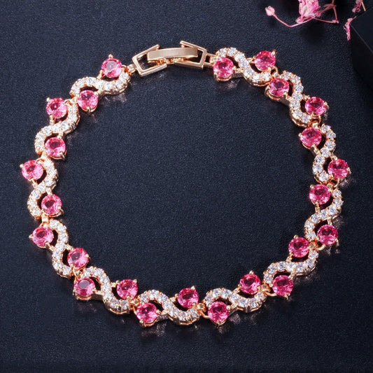 Elegant bracelet with pink gemstones and gold accents on a dark background