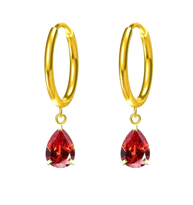 Gold hoop earrings with red teardrop-shaped gemstones on a white background
