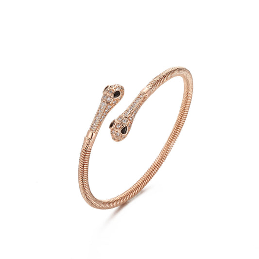 Rose gold snake-shaped bracelet with black accents on a white background