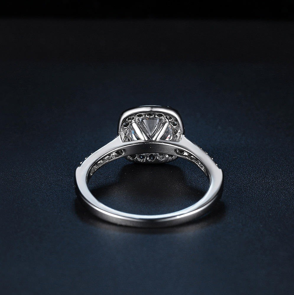 Silver ring with a diamond on a dark background