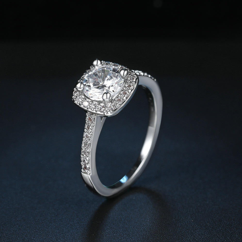 Silver ring with a large central gemstone on a dark background